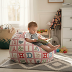 Toddler sitting on alphabet print kids bean bag chair reading in a nursery playroom