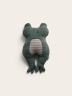 A dark green plush frog toy with a textured light beige belly, photographed against a solid off-white background.