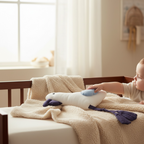 Baby playing with pelican plush toy with dangly legs in soft neutral nursery setting