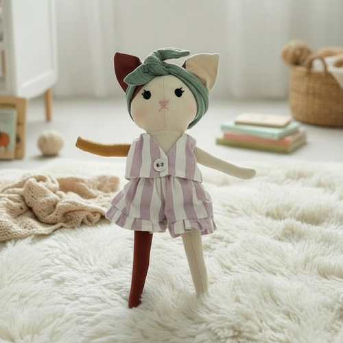 Soft cat heirloom doll in striped outfit standing on fluffy rug in neutral nursery setting
