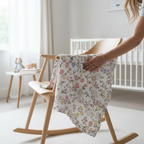 Floral muslin star baby comforter draped over chair showing soft breathable fabric for newborns