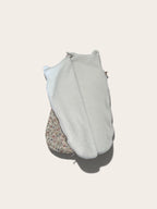 baby sleep sack with a floral print open showing the fleece lining 