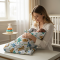 Mother holding newborn baby wrapped in soft animal print swaddle blanket in bright nursery