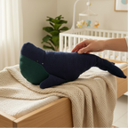 Navy and green whale plush toy in a nursery 