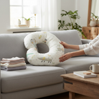 Nursing pillow for breastfeeding and baby support placed on sofa in modern home