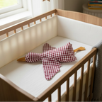 Baby crib with soft plush goose comforter toy in a warm neutral nursery setting