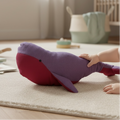Baby playing with soft whale comforter plush toy in purple and pink on nursery floor